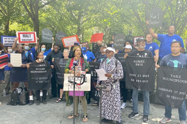 At a rally in front of City Hall earlier this month, protesters held signs with the names of incarcerated people who recently died at Rikers Island and called for a new city law to ban solitary confinement.